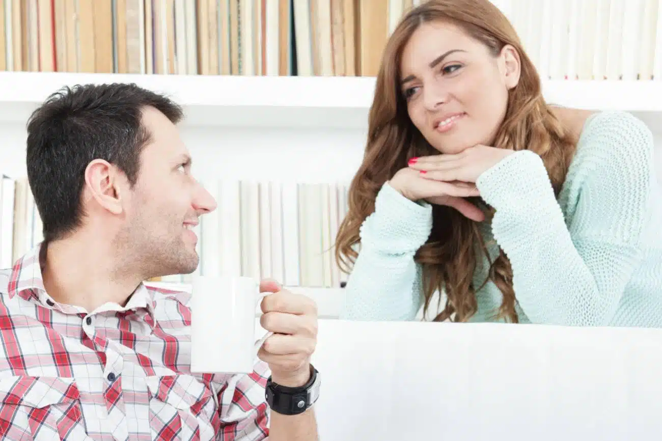 Femme souriante écoutant attentivement son partenaire lors d'une conversation