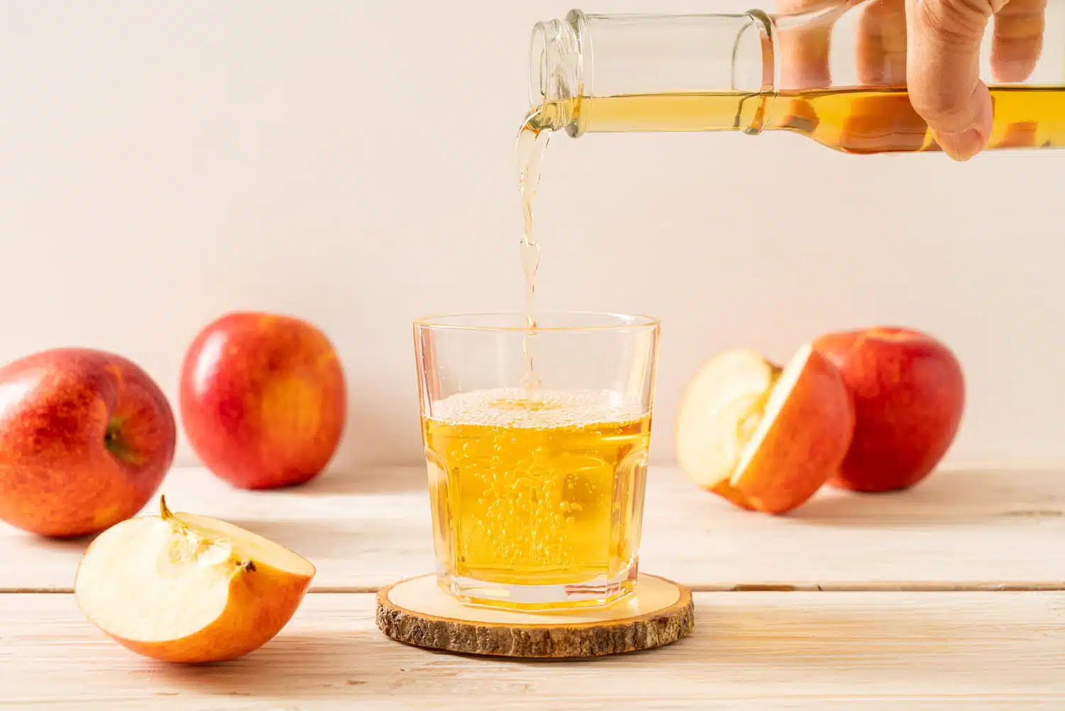 Bouteille de vinaigre de cidre et verre sur table en bois