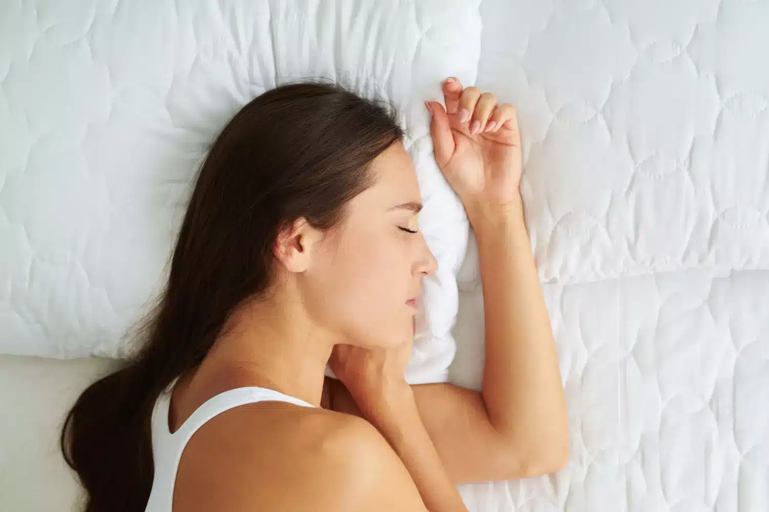 Personne dormant en position fœtale sur le côté avec coussin entre les genoux