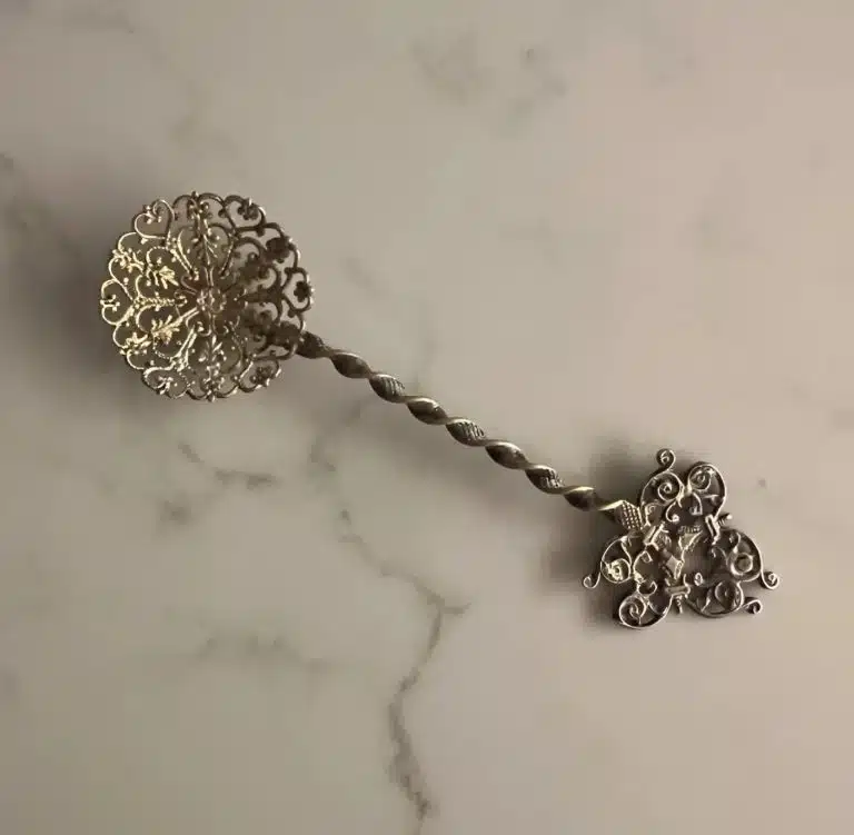 Cuillère à bonbons ancienne posée sur un tissu