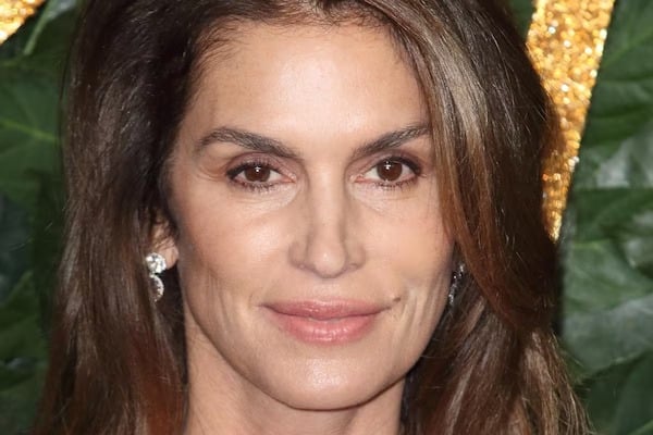 Cindy Crawford souriante, arborant des cheveux légèrement argentés avec naturel