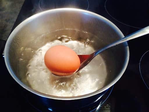 Casserole avec des œufs dans de l'eau sur une cuisinière