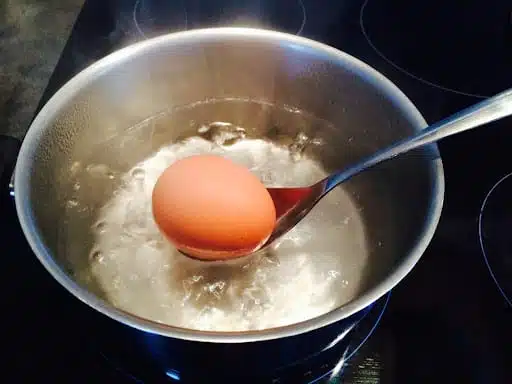 Casserole avec des œufs dans de l'eau sur une cuisinière
