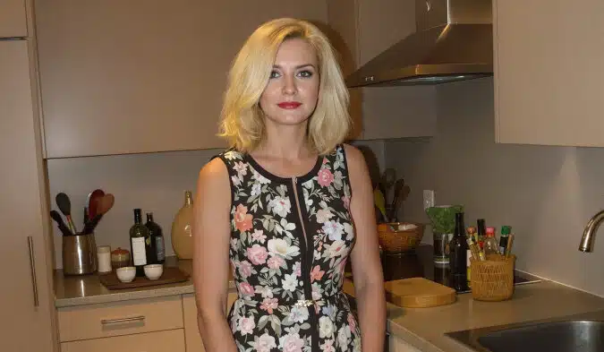 Femme regardant par l'entrebâillement d'une porte d'entrée, expression tendue