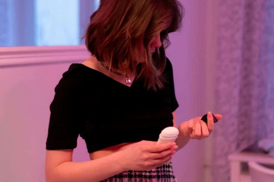 Femme appliquant du déodorant en spray sous son bras