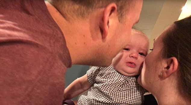 Les parents embrassent leur bébé Ella