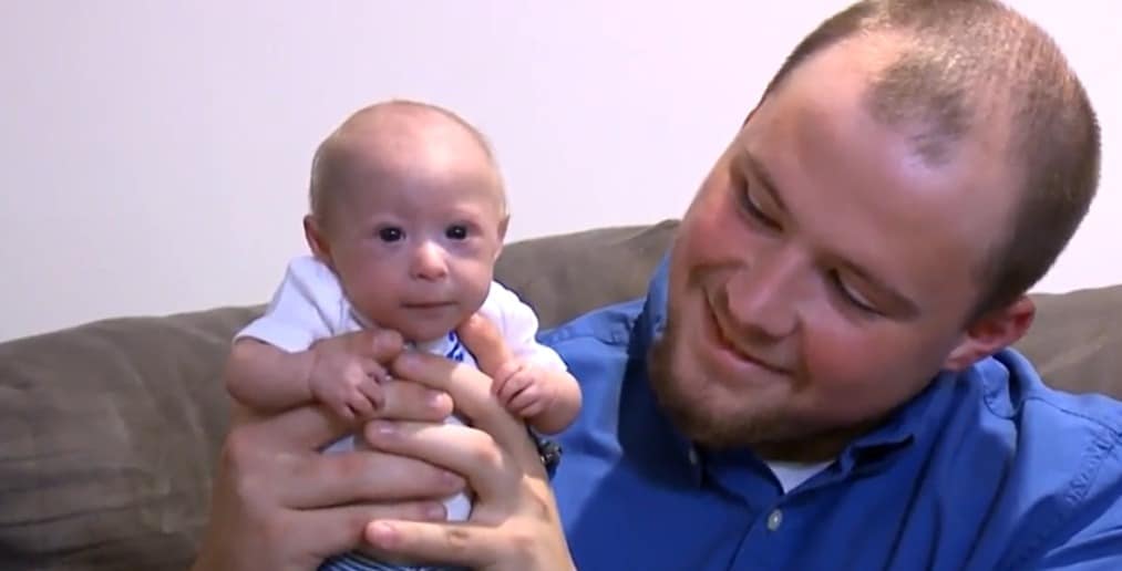 Photo de famille souriante avec Mathieu au centre, entouré de ses parents et frères