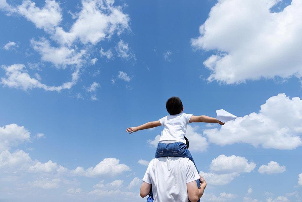 Un papa portant son fils sur son dos