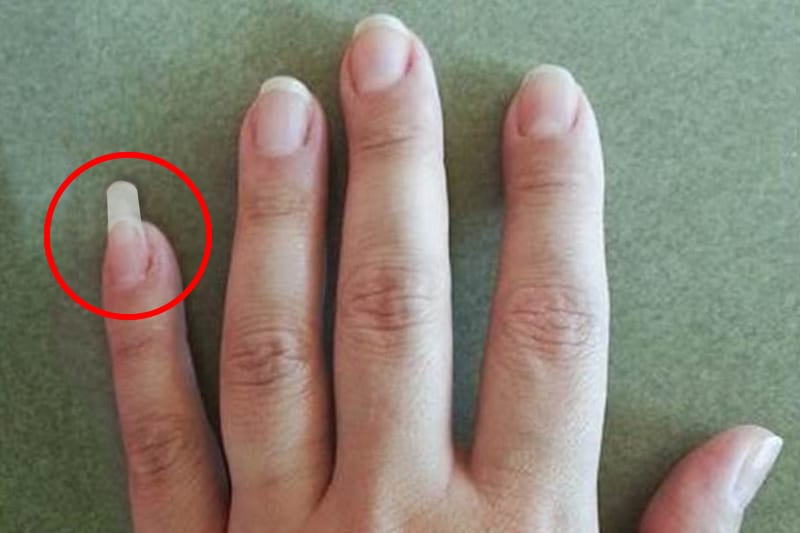 Homme utilisant son ongle long de l'auriculaire comme outil pratique