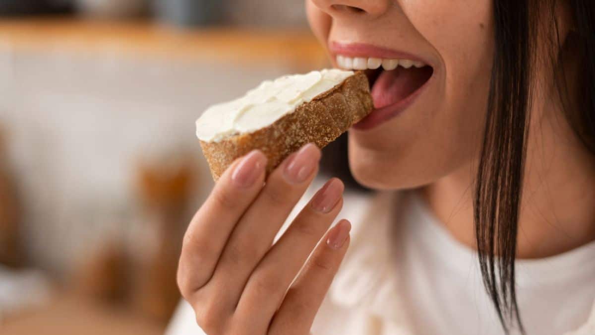Personne tenant un sandwich avec inconfort digestif