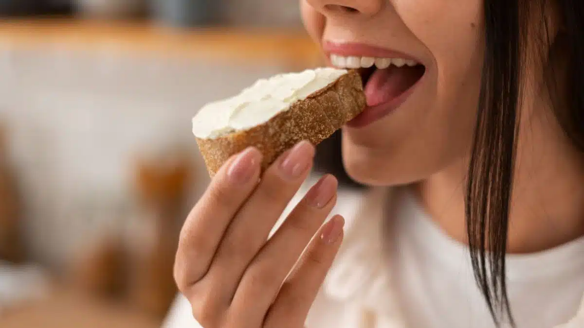 Personne tenant un sandwich avec inconfort digestif