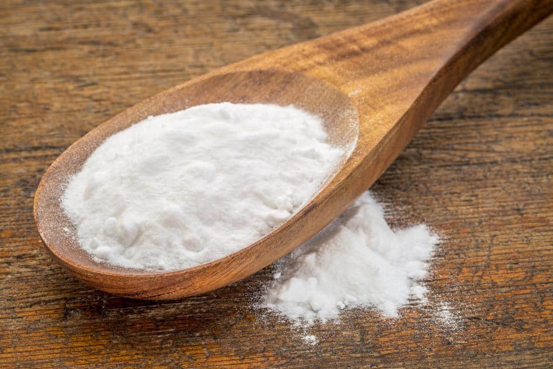 Bicarbonate de soude sur une cuillère, produit polyvalent pour l'entretien