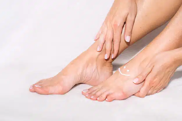 Application d'une crème hydratante sur les jambes