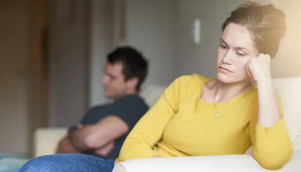 Femme regardant par la fenêtre, expression pensive