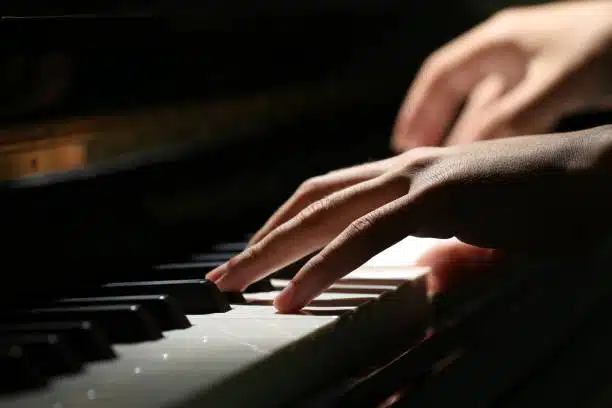 Mains jouant du piano dans une ambiance feutrée