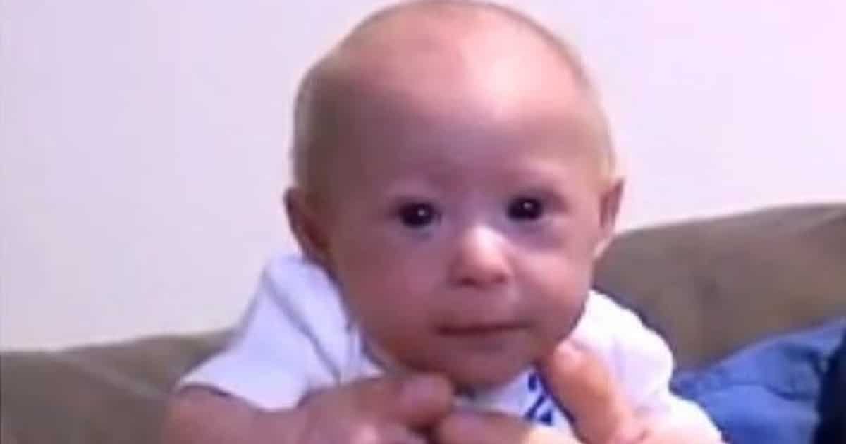 Une main d'adulte tient délicatement la petite main de Mathieu