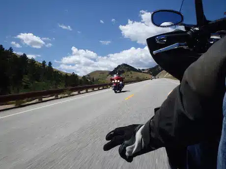 Motard effectuant le signe de la main sur route