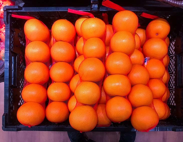 Des oranges dans des filets rouges 