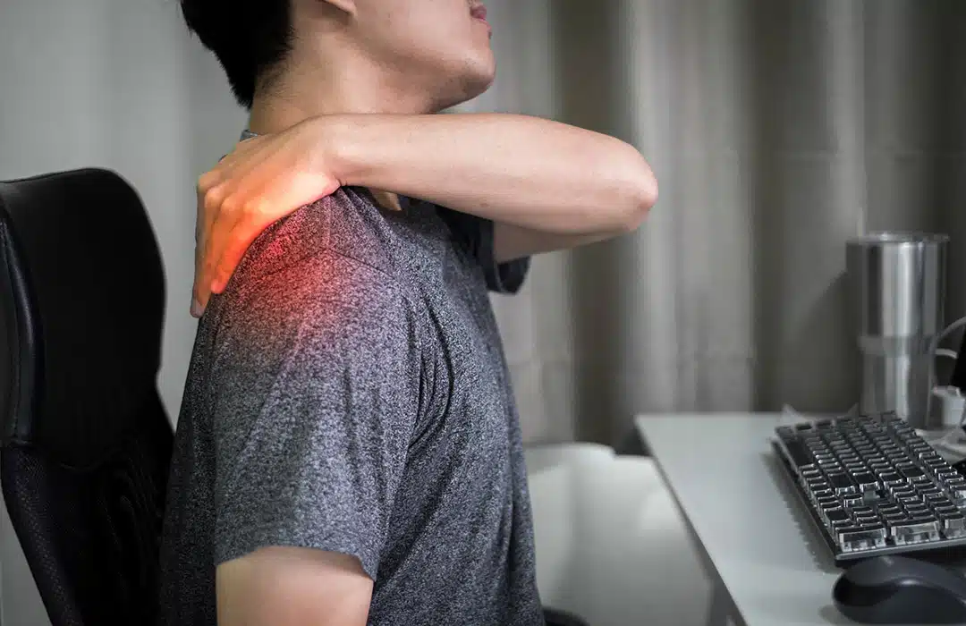 Personne se massant les épaules pour soulager des tensions musculaires