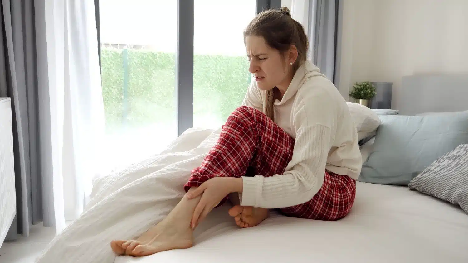 Femme se réveillant avec une crampe au mollet