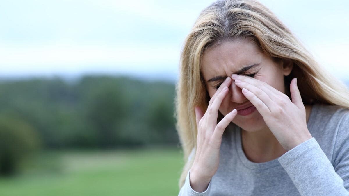 Femme se frottant les yeux à cause de démangeaisons