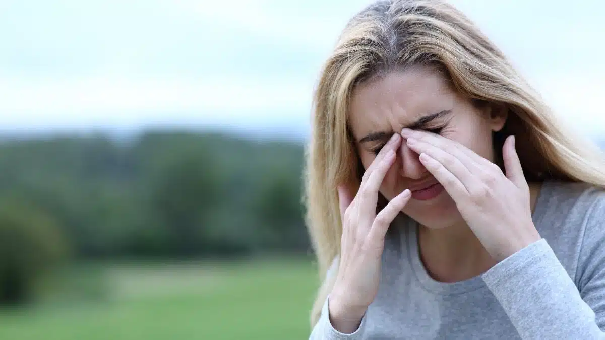 Femme se frottant les yeux à cause de démangeaisons